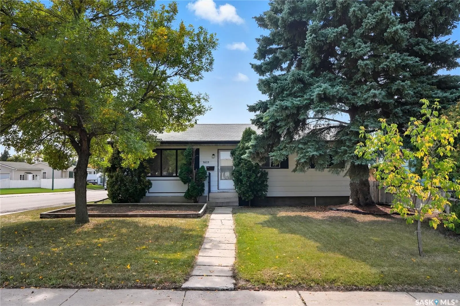 Exterior photo of 3803 miyo-wâhkôhtowin Road Saskatoon SK showcasing a mid-century bungalow on a corner lot.